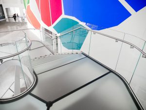 A close up view of the Queens Museum Staircase with low iron, laminated acid-etched walkable traction-glass stairs.